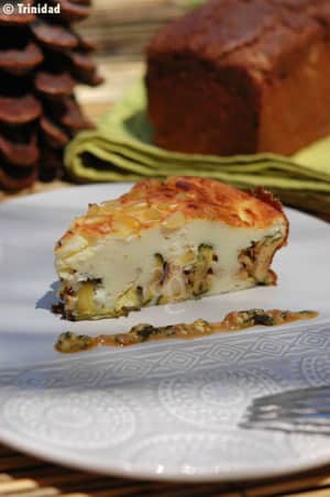 Part de gâteau aux courgettes grillées et fromage servie avec une cuillère de pesto de tomate au basilic
