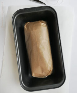 Poitrine de dinde enroulée et ficelée dans du papier cuisson avant cuisson au four